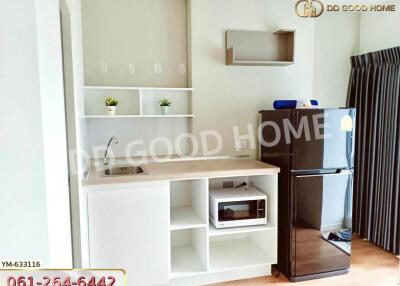 Compact kitchenette with shelves, microwave, and a fridge