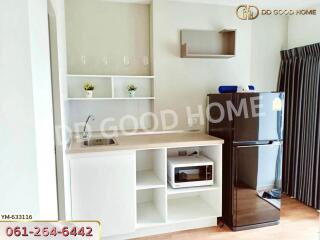 Compact kitchenette with shelves, microwave, and a fridge