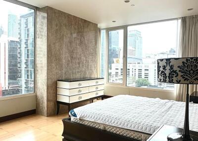 Spacious bedroom with large windows and urban view