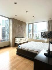 Spacious bedroom with large windows and urban view