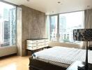 Spacious bedroom with large windows and urban view