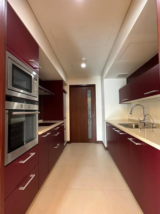 Modern kitchen with red cabinetry and stainless steel appliances