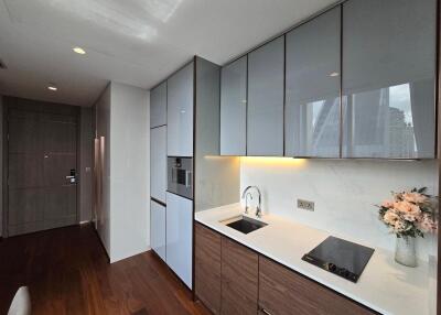 Modern kitchen with sleek cabinets, built-in appliances, and a floral arrangement