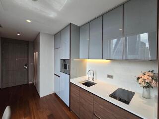 Modern kitchen with sleek cabinets, built-in appliances, and a floral arrangement