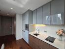 Modern kitchen with sleek cabinets, built-in appliances, and a floral arrangement