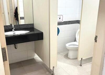 Spacious bathroom with adjacent toilet stall