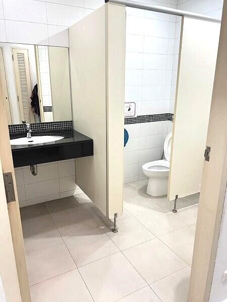 Spacious bathroom with adjacent toilet stall