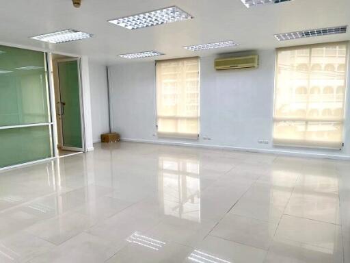 Spacious and bright living area with large windows and polished tile flooring