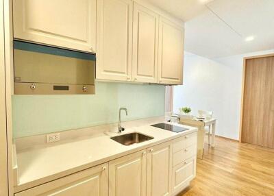 Modern kitchen with light-colored cabinets and wood flooring