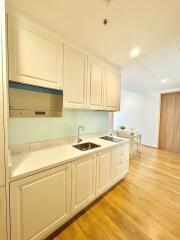 Modern kitchen with light-colored cabinets and wood flooring