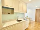 Modern kitchen with light-colored cabinets and wood flooring