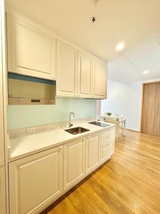 Modern kitchen with light-colored cabinets and wood flooring