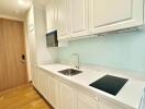 Modern kitchen with white cabinetry and wooden flooring