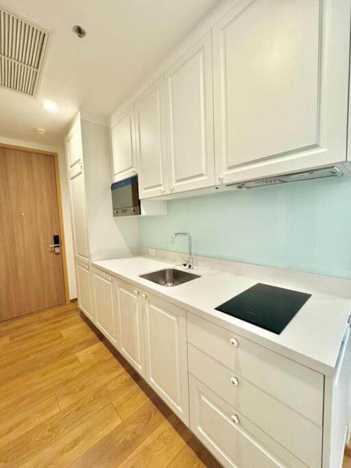 Modern kitchen with white cabinetry and wooden flooring