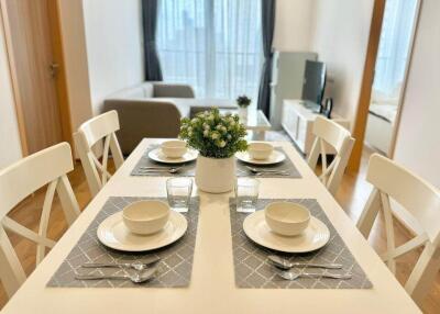 Bright and minimalistic dining area with a view of living space