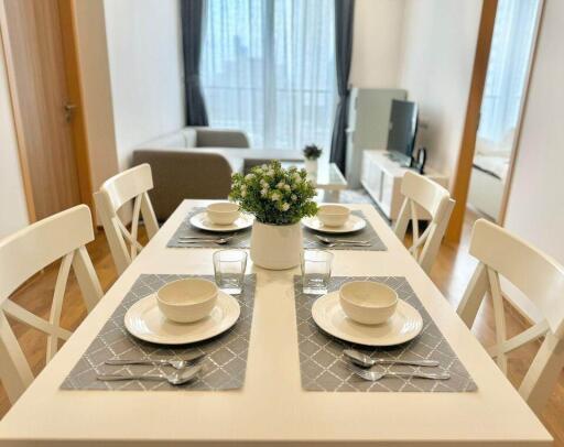 Bright and minimalistic dining area with a view of living space