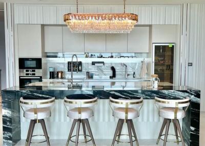 Modern kitchen with island, bar stools, and chandelier