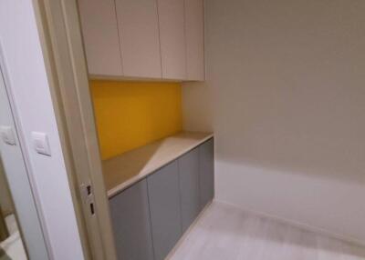 Compact kitchen area with cabinets and yellow backsplash