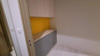 Compact kitchen area with cabinets and yellow backsplash