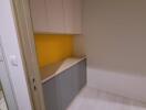 Compact kitchen area with cabinets and yellow backsplash