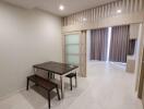 Modern dining area with a table and two benches adjacent to a living space