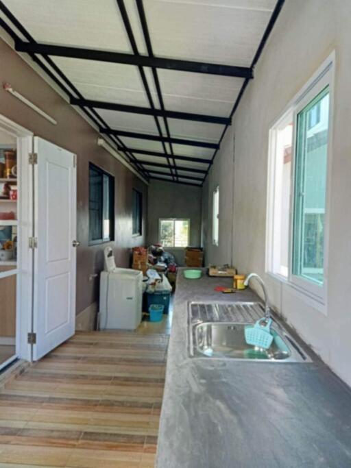 Narrow kitchen with sink, window, and pantry door