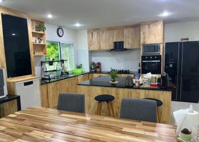 Spacious modern kitchen with wooden cabinets and black appliances