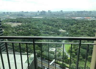 View from balcony overlooking a vast green area and cityscape