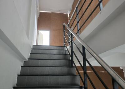 Staircase with metal railing and dark tiles