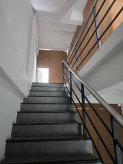 Staircase with metal railing and dark tiles