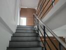 Staircase with metal railing and dark tiles