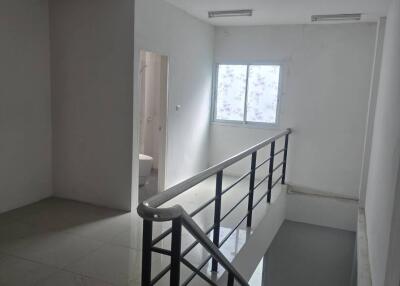 well-lit stairwell with white tiled flooring