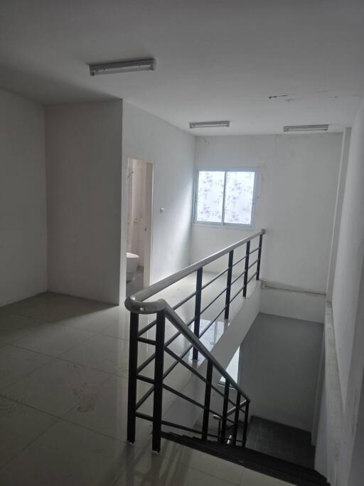 well-lit stairwell with white tiled flooring