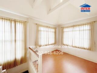 Bright living area with wooden flooring and multiple windows