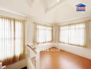 Bright living area with wooden flooring and multiple windows