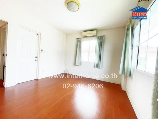 Empty bedroom with wooden floor and large window