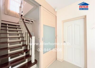 Bright hallway with staircase and door