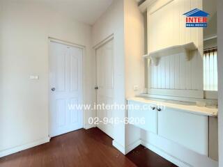 Hallway with white doors and a small built-in shelf and cabinet