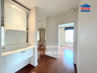 Interior hallway leading to a room with wooden floors