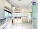 Well-lit kitchen with white cabinets and granite countertops