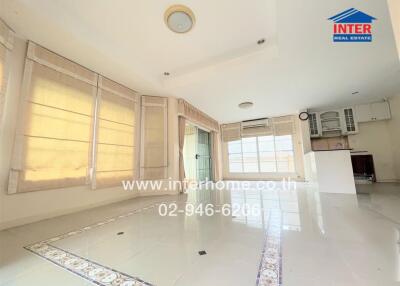 Spacious and bright living area with large windows and tiled flooring