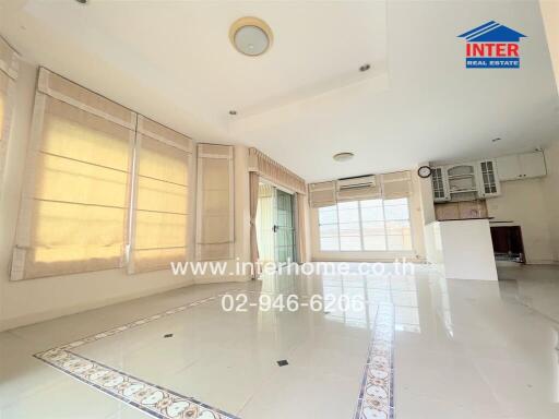 Spacious and bright living area with large windows and tiled flooring