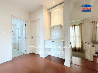 White bedroom with wooden flooring and built-in shelves