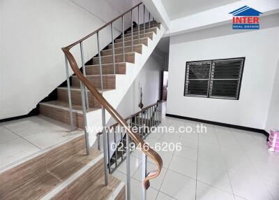 Interior staircase with wooden handrail and metal balusters