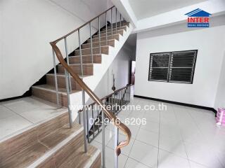 Interior staircase with wooden handrail and metal balusters