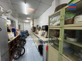 Long kitchen with various appliances and storage shelves