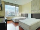 Spacious bedroom with two beds and city view