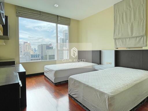 Spacious bedroom with two beds and city view