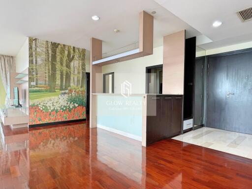 Living space with wooden flooring and forest mural