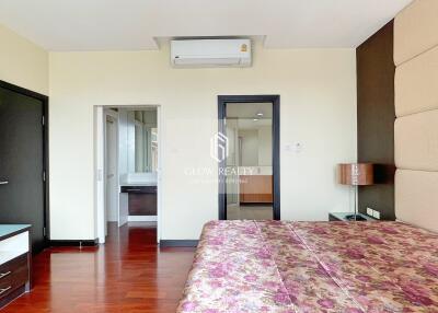 Bedroom with floral bedspread and view of adjoining bathroom